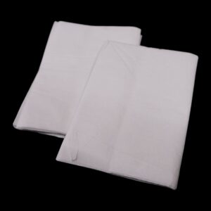 Two neatly folded white cloths on a black background.