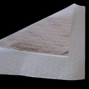 Close-up of a white paper towel with textured patterns on a black background.
