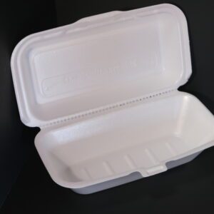 Open white styrofoam takeout container on black surface.