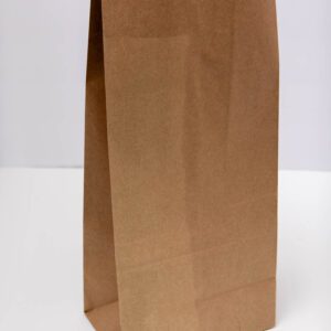 A plain brown paper bag standing upright on a white surface.