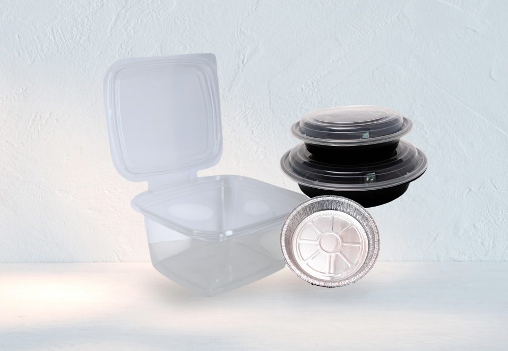 Stacked black and clear plastic food containers with lids on a white surface.