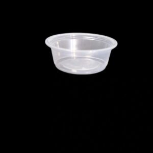 A clear plastic condiment cup on a black background.