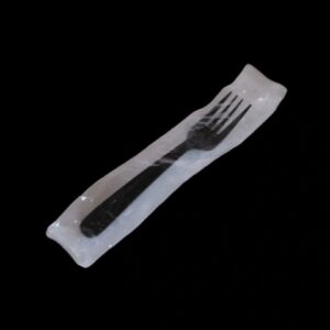 A fork in a clear plastic wrapper on a black background.