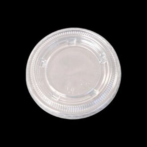 Clear plastic lid with a raised circular design against a black background.